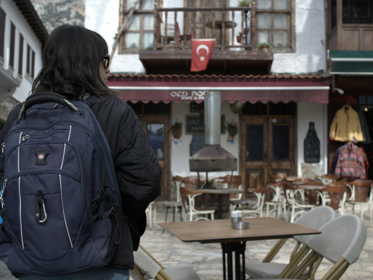 a person with a backpack is standing in front of a building