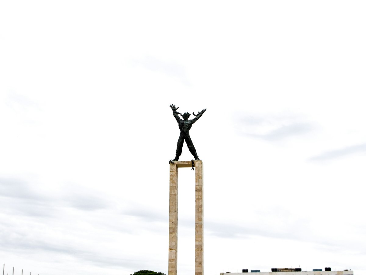 a man standing on top of a wooden pole