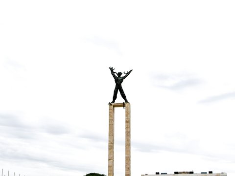 a man standing on top of a wooden pole