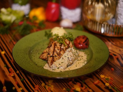 a green plate topped with meat and vegetables