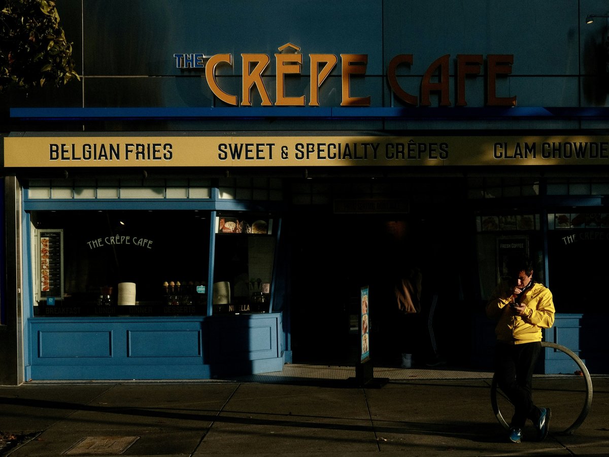 a man walking down a street next to a building