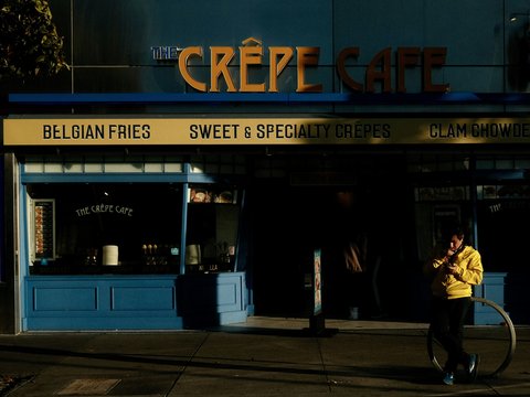 a man walking down a street next to a building