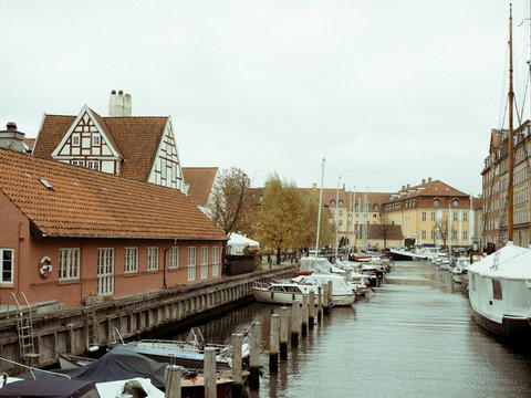boats on body of water near houses during daytime