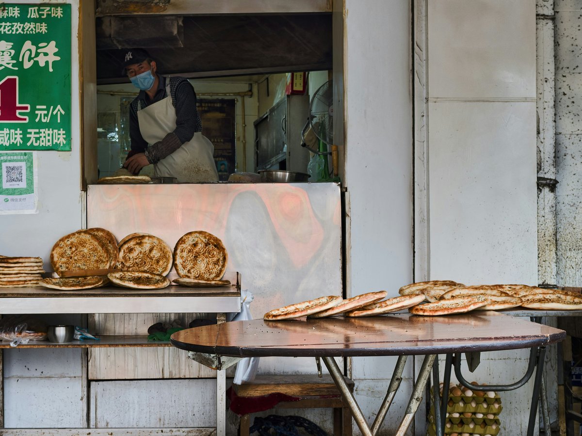 Baker preparing flatbreads at an outdoor stall
