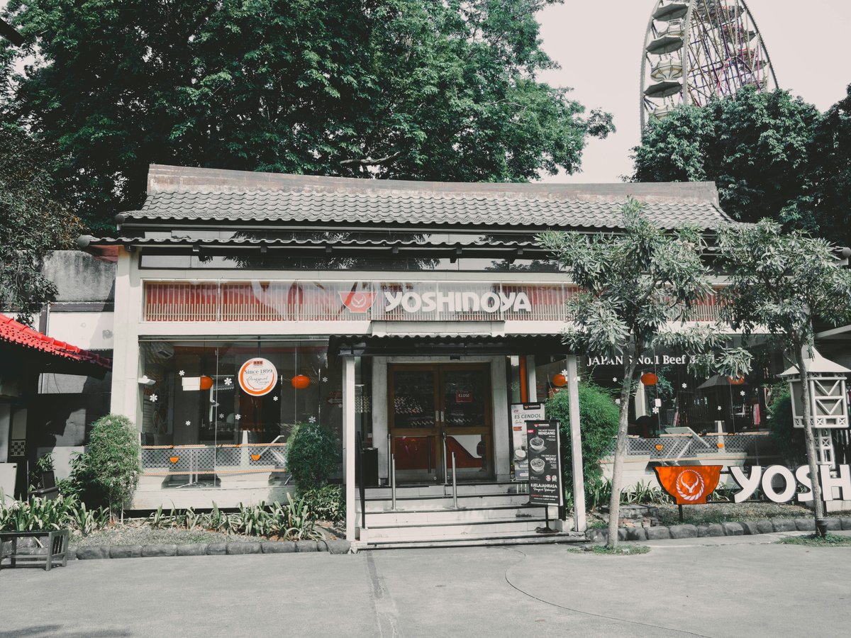 an asian restaurant with a ferris wheel in the background