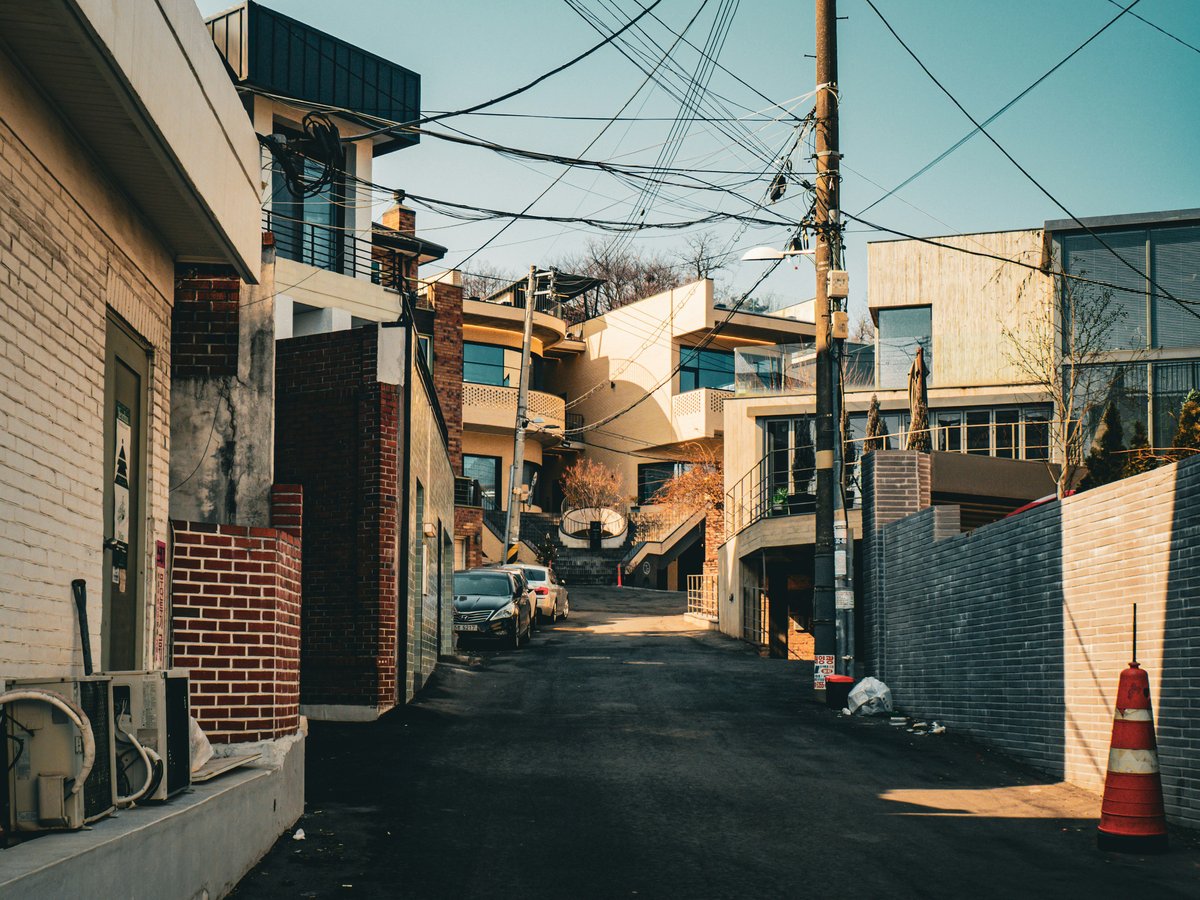 Narrow street between buildings with power lines overhead