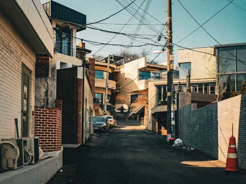 Narrow street between buildings with power lines overhead