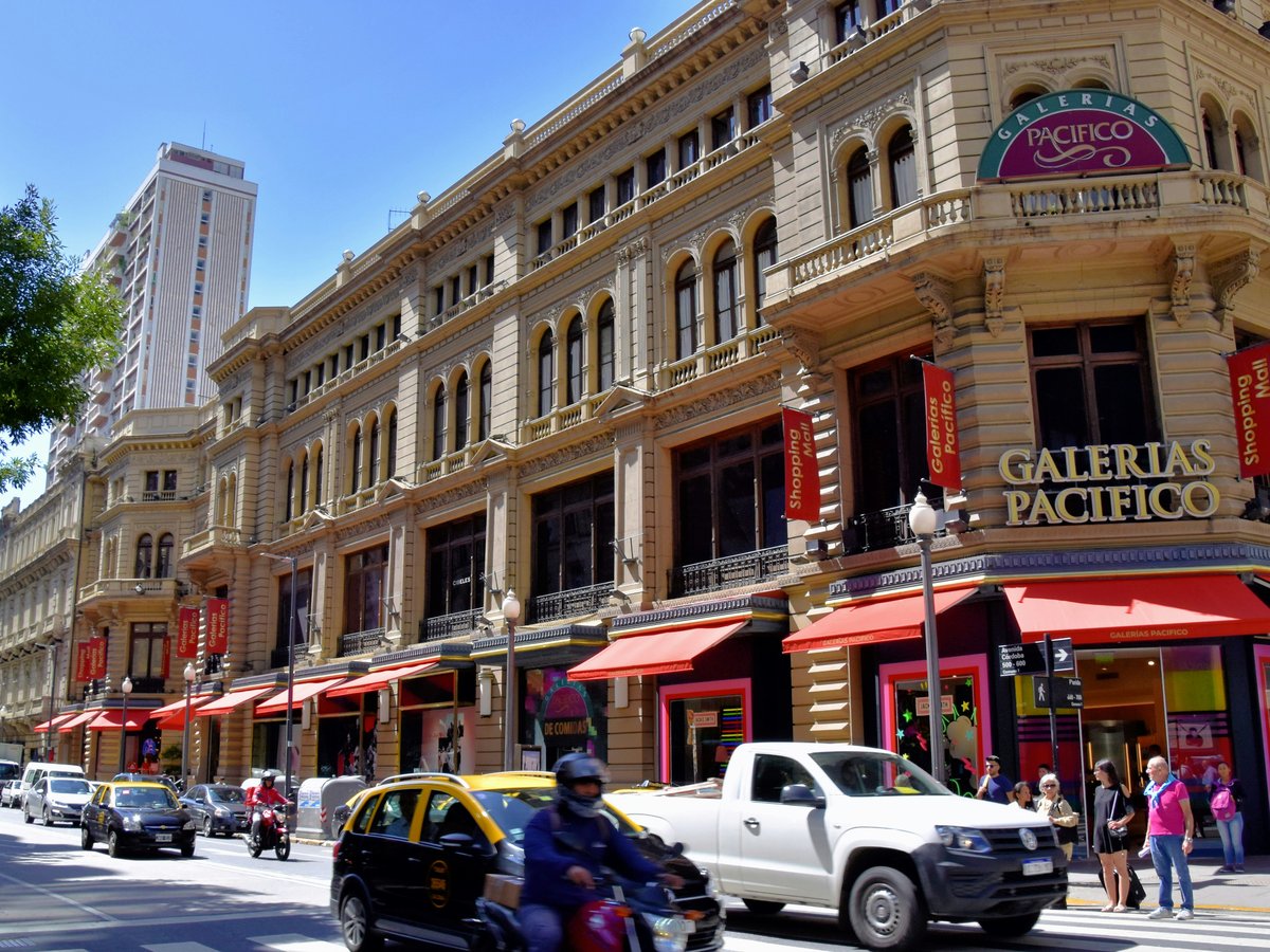 a busy city street with cars, motorcycles and pedestrians