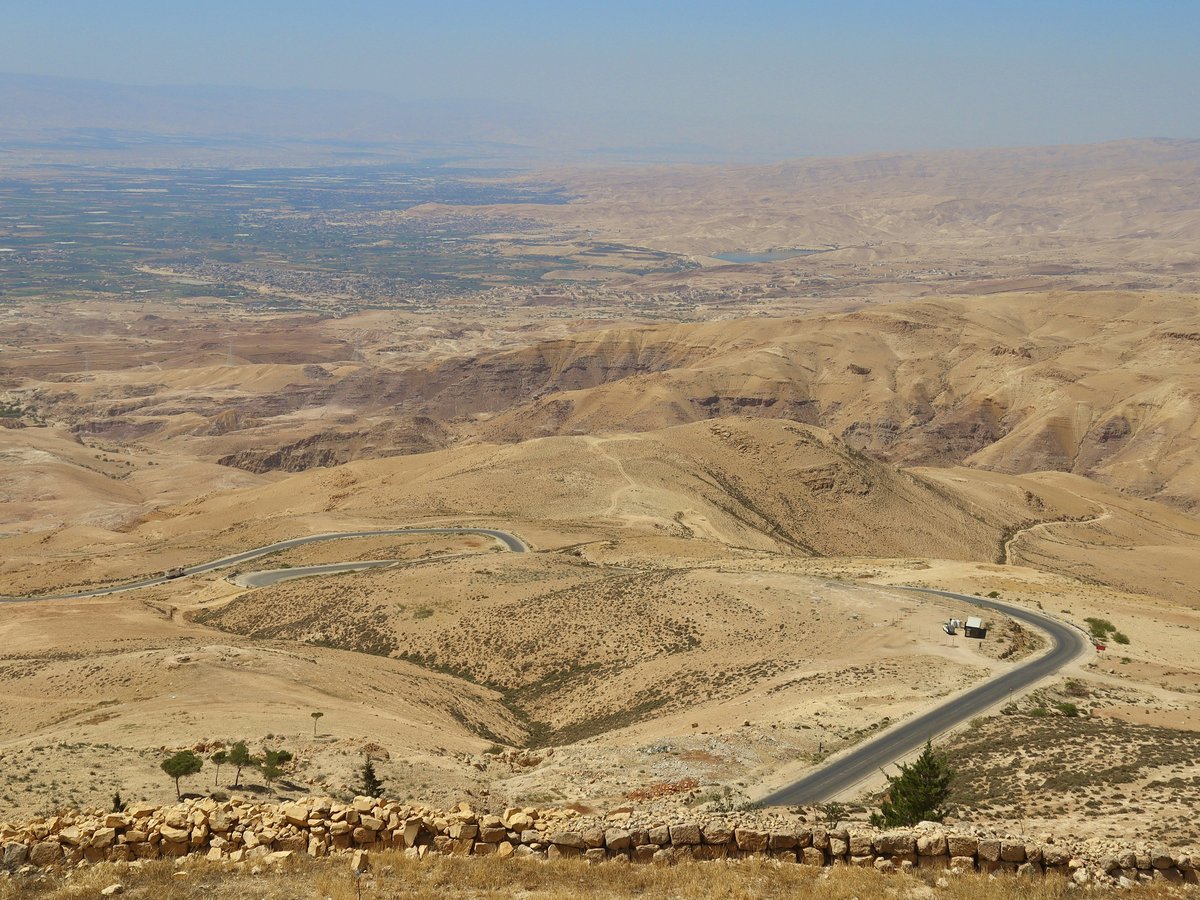 a car driving down a road in the middle of the desert
