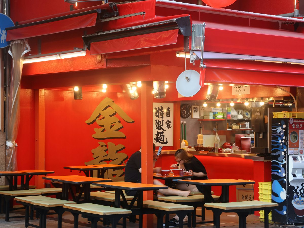 A restaurant with red walls and tables and chairs