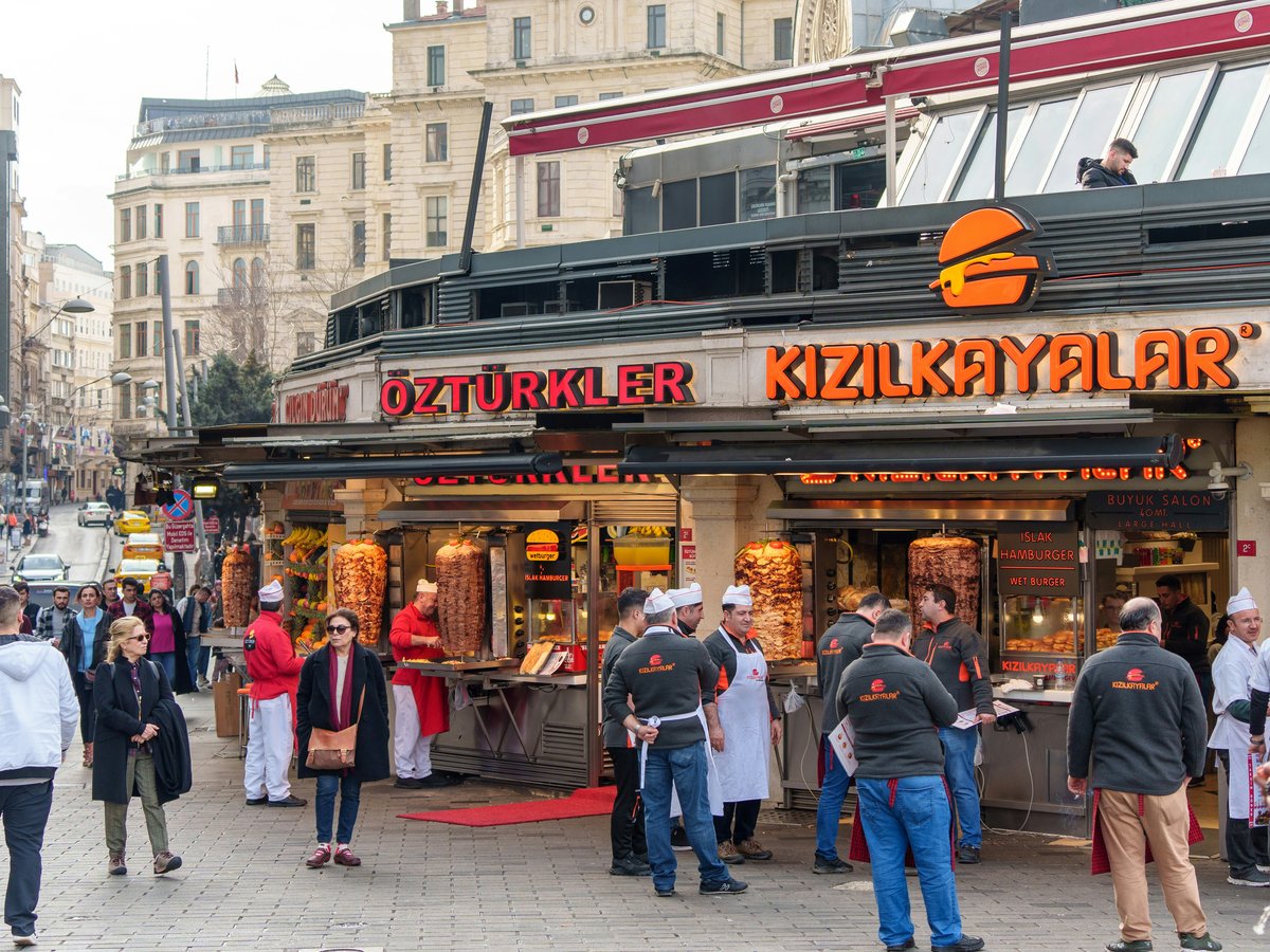 a group of people standing outside of a kiosk