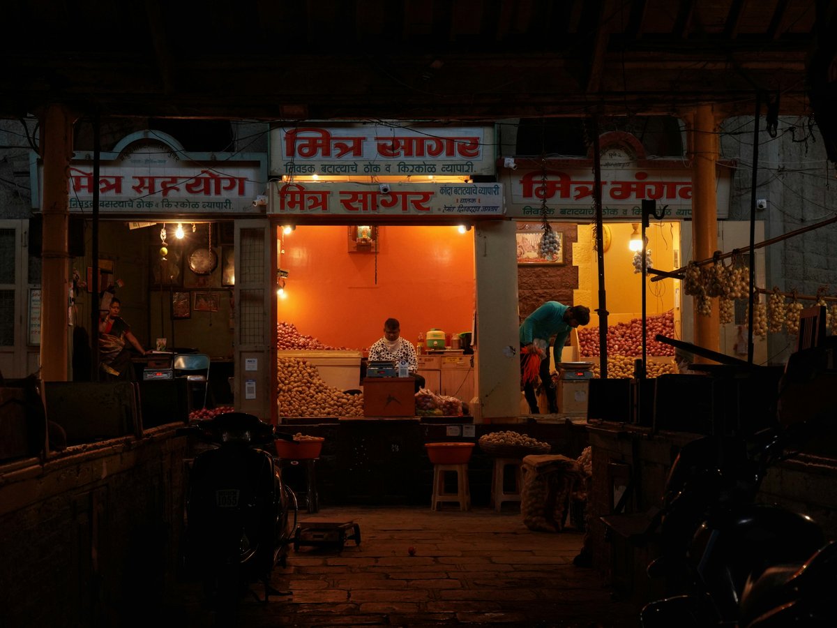 a man standing outside of a store at night