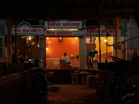 a man standing outside of a store at night
