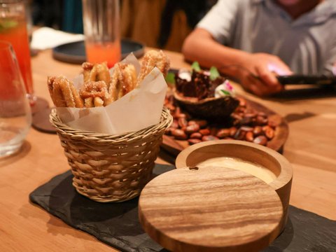 A person sitting at a table with a basket of food