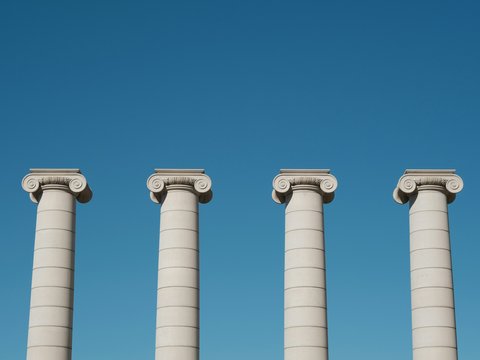 a row of white pillars against a blue sky