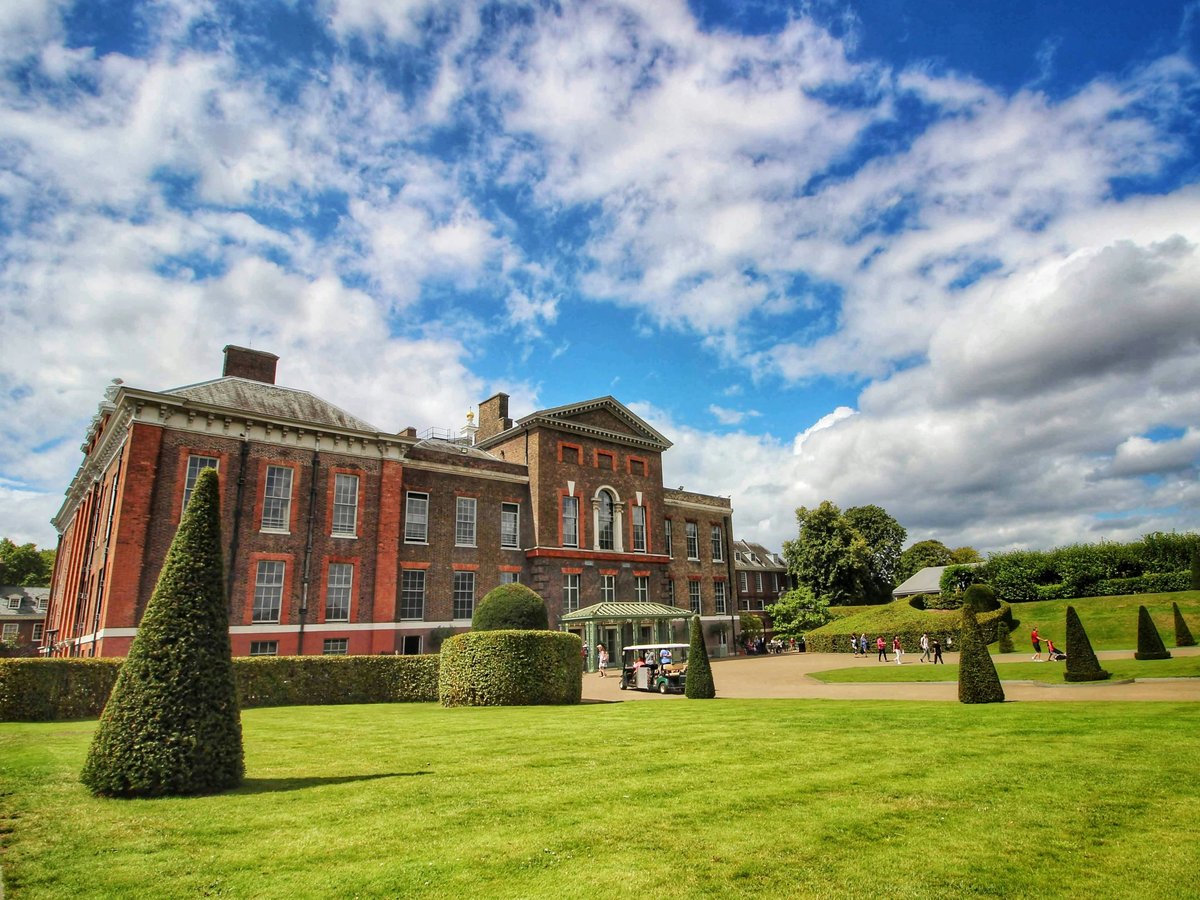 a large red brick building sitting on top of a lush green field