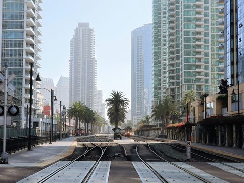 gray concrete road between high rise buildings during daytime