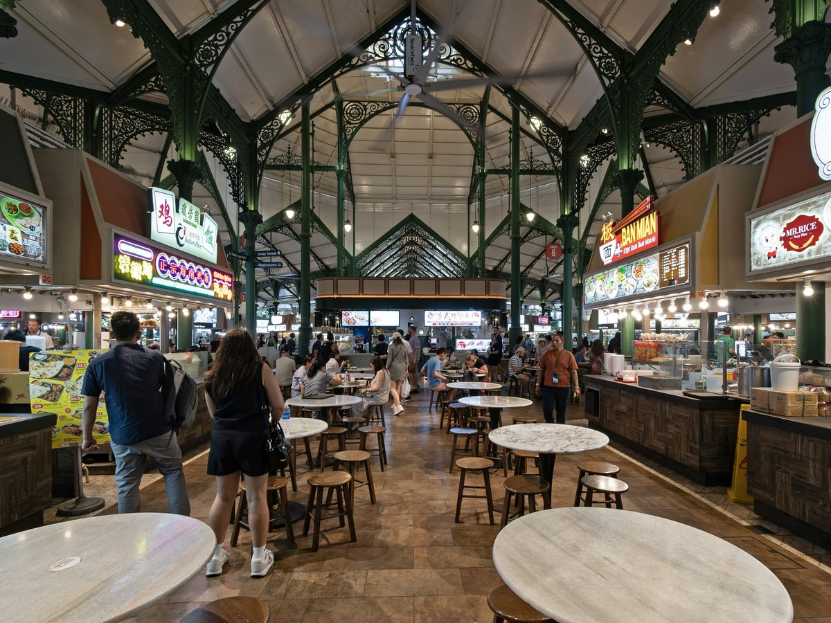 A group of people walking through a food court