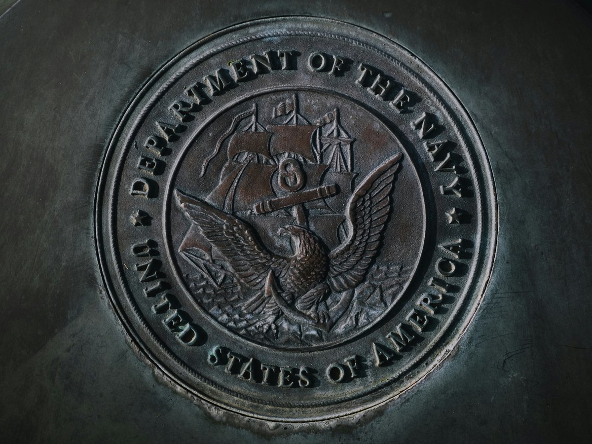 silver round coin on gray textile