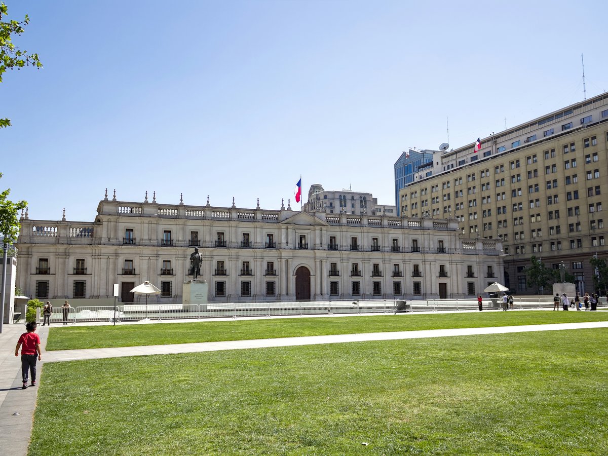 Grand government building with a green lawn and clear sky