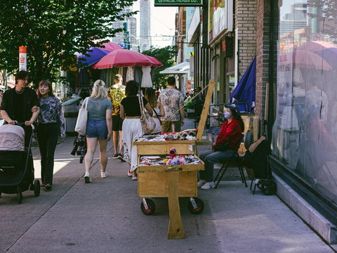 A group of people walking down a sidewalk