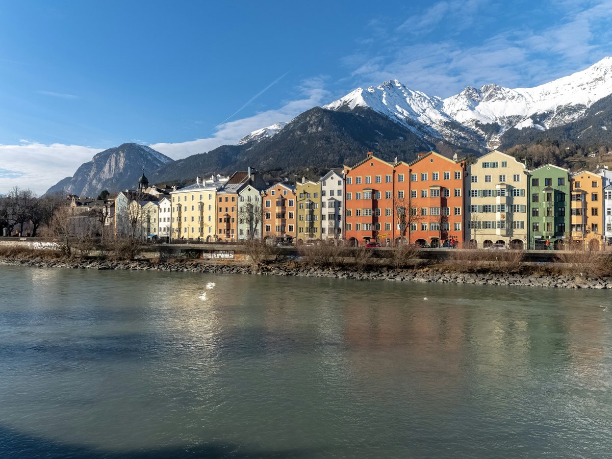 a river running through a city with mountains in the background