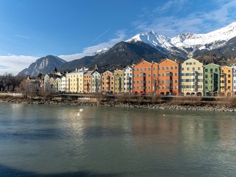 a river running through a city with mountains in the background