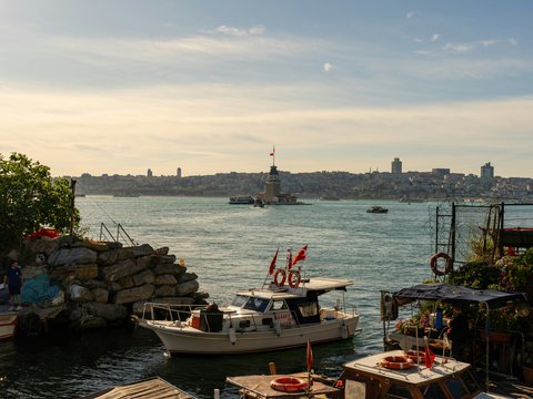 Sunny view of boats, maiden's tower, and istanbul skyline.