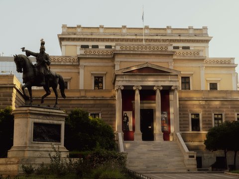 A statue of a man on a horse in front of a building