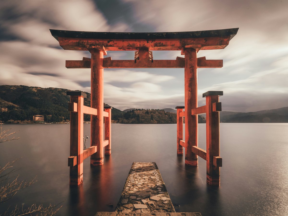 A red torii gate standing in the water at Lake Ashi in Hakone, Japan