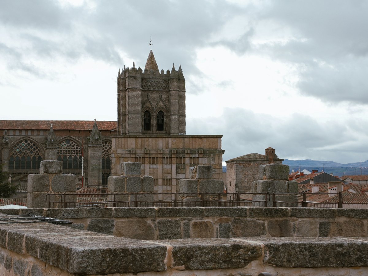 a stone wall with a clock tower in the background