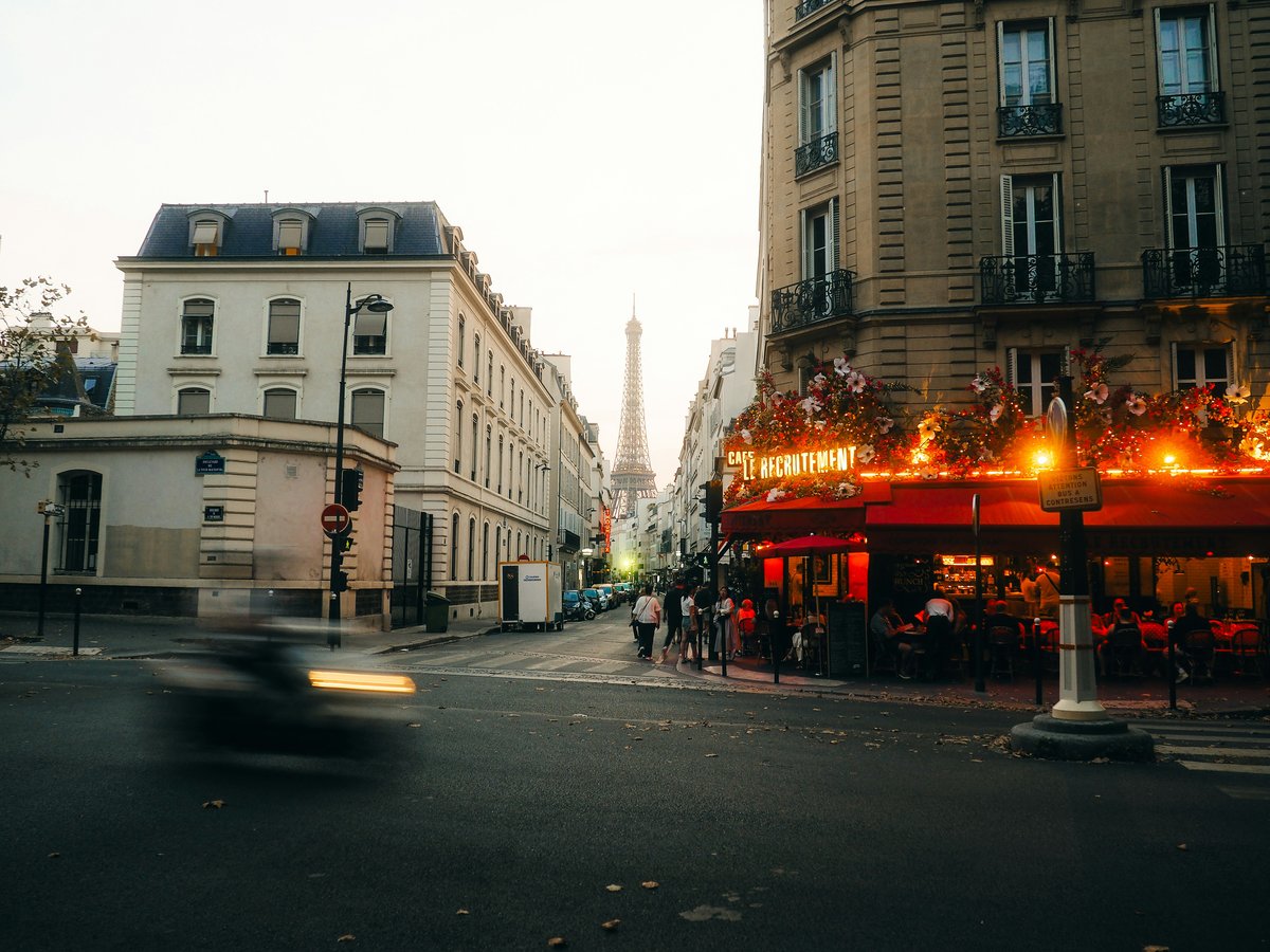 Eiffel tower visible from a parisian street cafe.