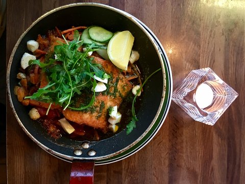 Salmon fillet with vegetables in a pan