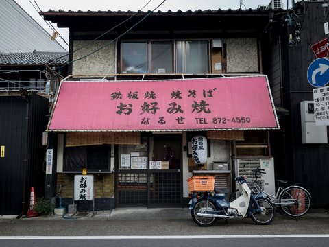 Japanese restaurant with red awning and parked motorcycle