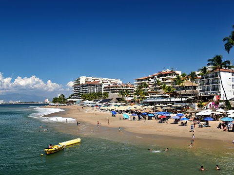 People relax on a sunny beach with ocean waves
