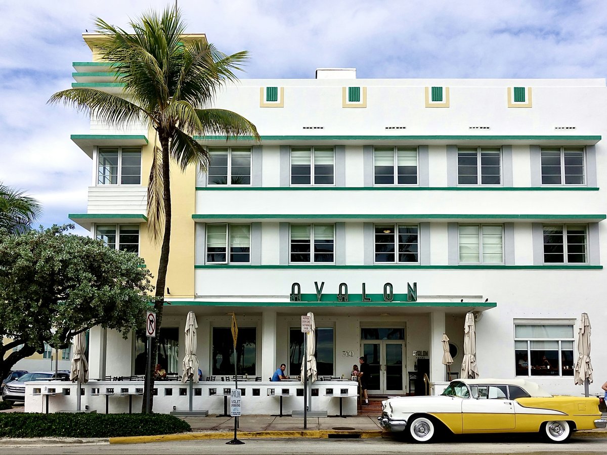 white and yellow coupe parking near white and green building under white and blue sky