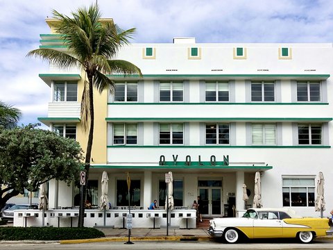 white and yellow coupe parking near white and green building under white and blue sky