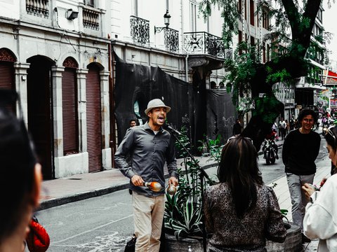 A group of people standing on the side of a street