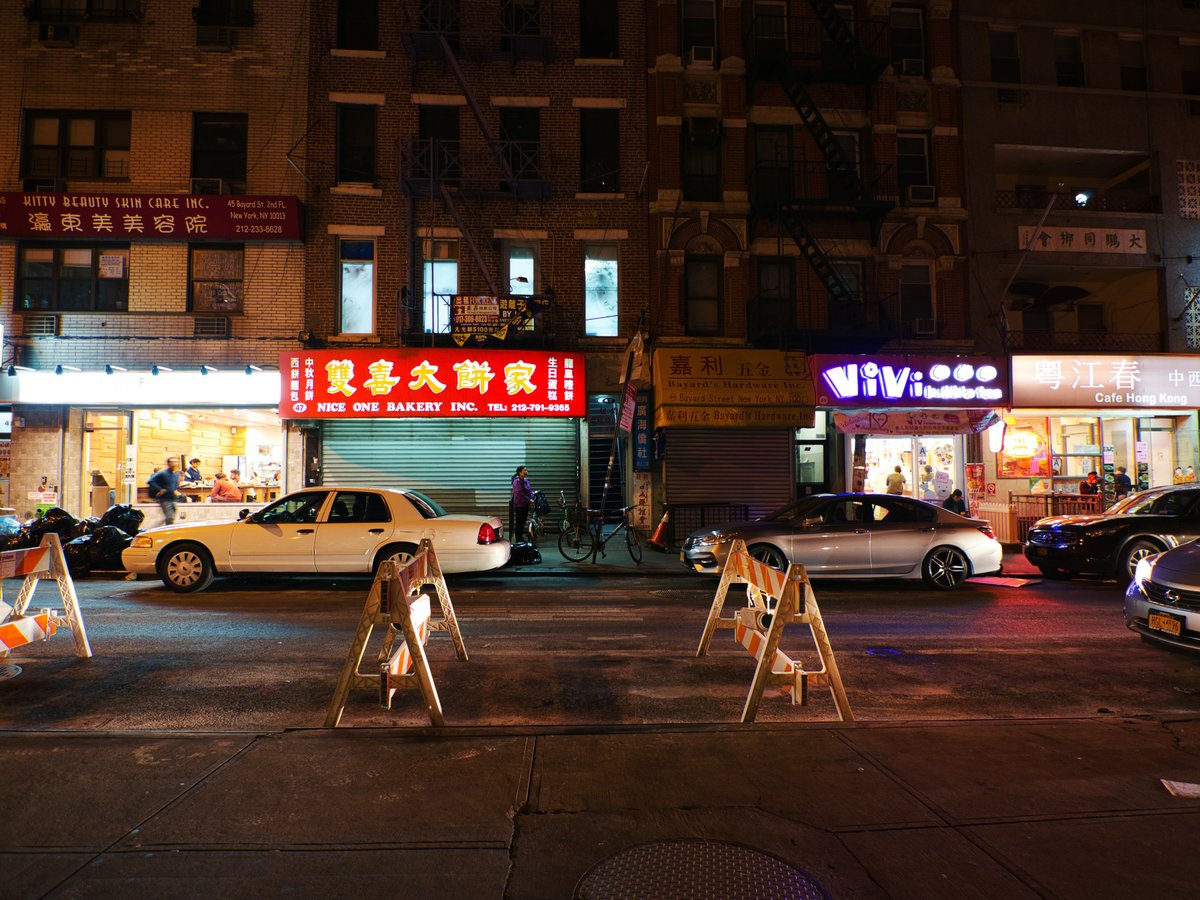 cars parked in front of brown building during night time