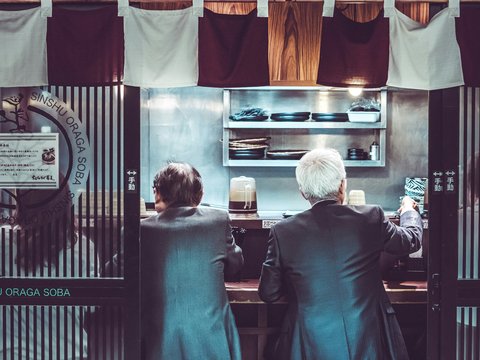 two men and woman sitting inside restaurant