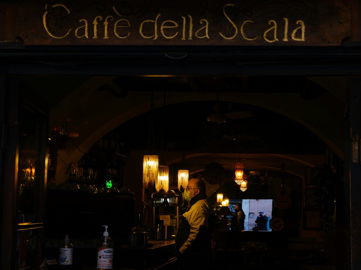 a man standing in front of a bar at night