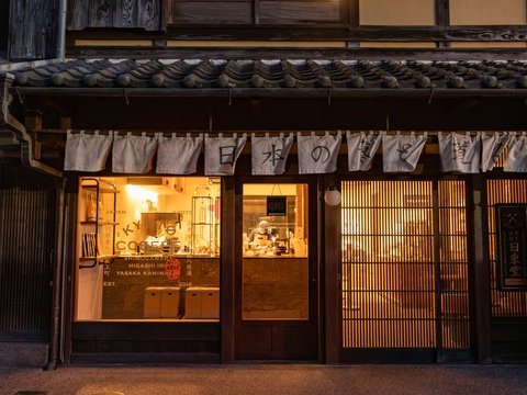 A store front with a lit up window at night