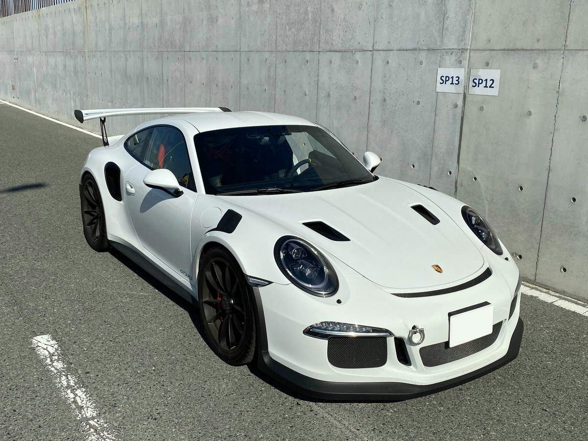 white porsche 911 parked on gray pavement