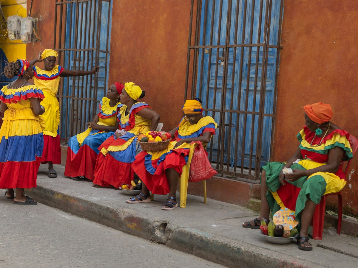 a group of people sitting on the side of a street