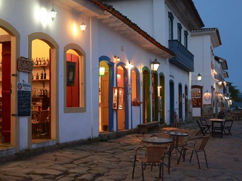 a cobblestone street lined with tables and chairs