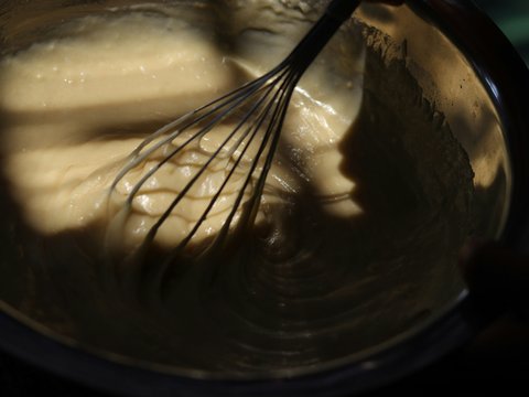 Whisk mixing a creamy sauce in a bowl.