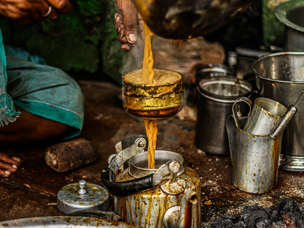 a person pouring something into a pot on a stove
