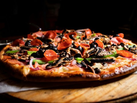 a pizza sitting on top of a wooden cutting board