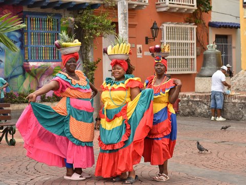 a group of women in colorful dresses standing next to each other