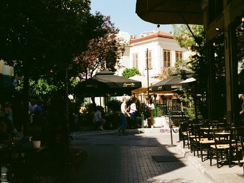 a group of people sitting at tables under umbrellas